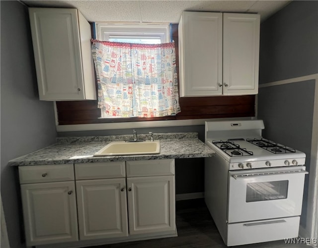 kitchen featuring dark hardwood / wood-style flooring, white cabinetry, a textured ceiling, sink, and white gas range oven