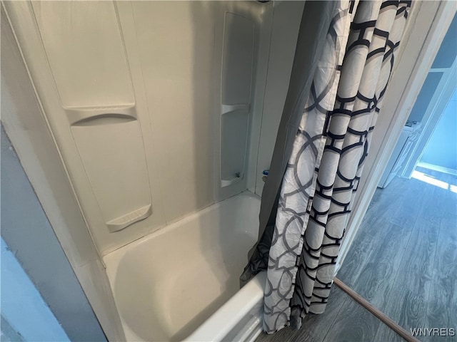 bathroom featuring hardwood / wood-style flooring and shower / bath combo with shower curtain