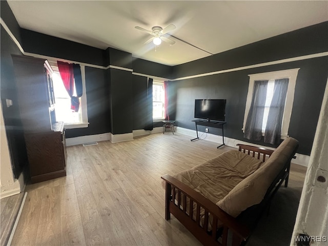 living room with light hardwood / wood-style flooring and ceiling fan