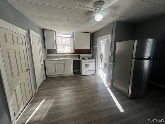 kitchen featuring dark hardwood / wood-style flooring, white cabinetry, stainless steel refrigerator, white range with gas stovetop, and sink