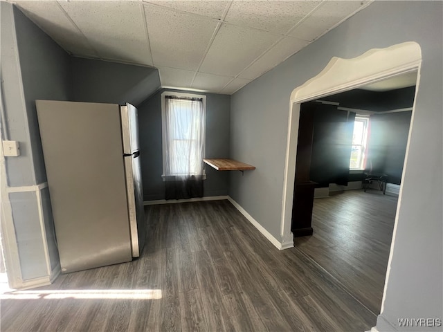 kitchen featuring dark hardwood / wood-style flooring, a paneled ceiling, and stainless steel refrigerator