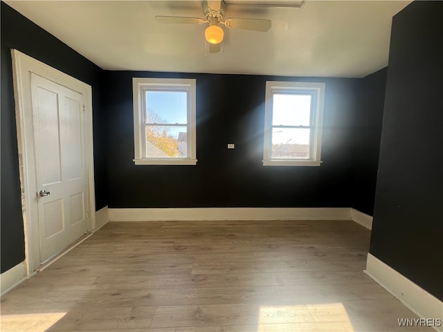 spare room featuring light hardwood / wood-style flooring and ceiling fan