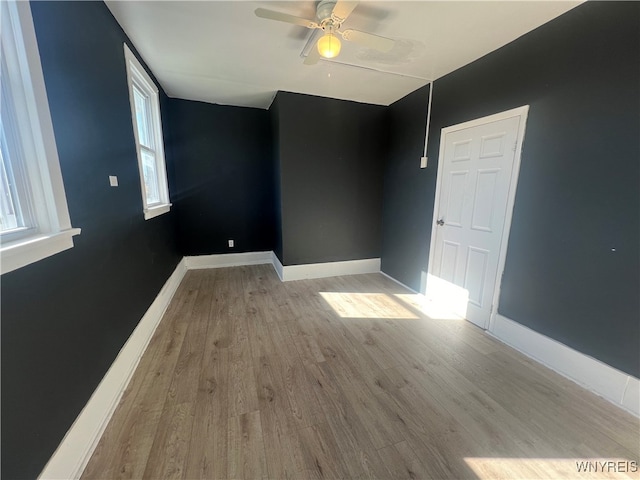 unfurnished room featuring light hardwood / wood-style floors, a healthy amount of sunlight, and ceiling fan