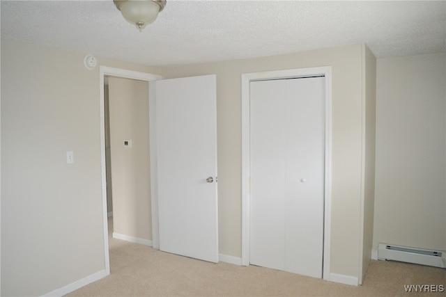 unfurnished bedroom featuring light carpet, a textured ceiling, a closet, and a baseboard heating unit