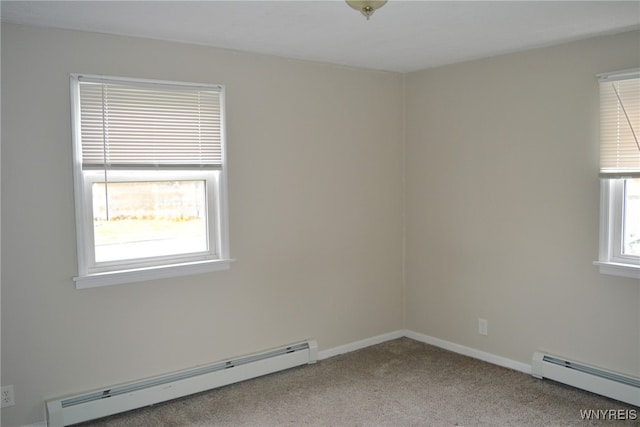 carpeted spare room featuring baseboard heating