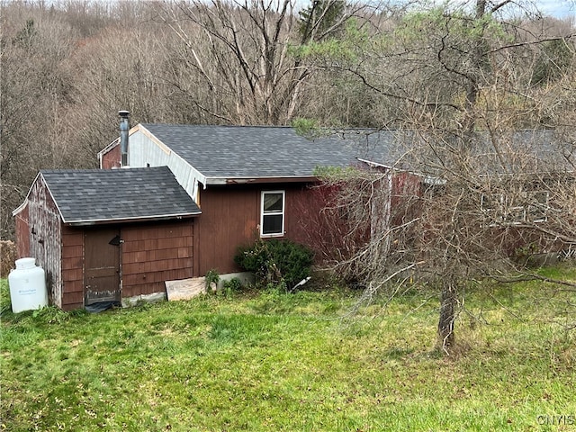 view of home's exterior featuring a storage unit and a lawn