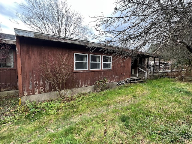 view of side of home with a yard