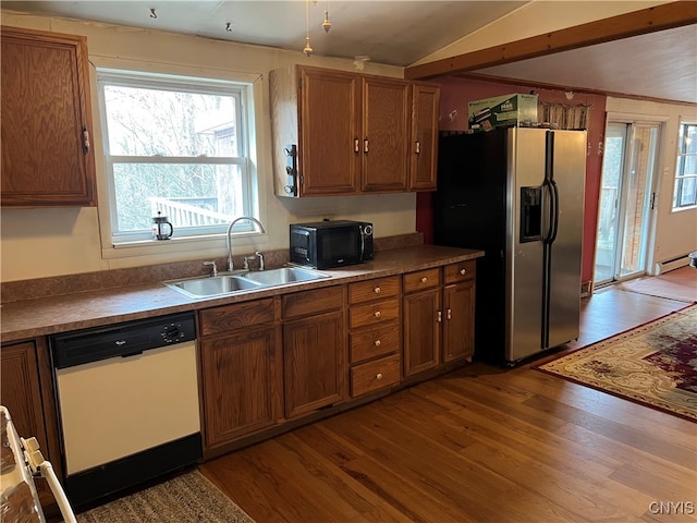 kitchen featuring sink, dishwasher, wood-type flooring, and stainless steel fridge