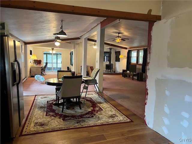 dining area with a wood stove and hardwood / wood-style floors