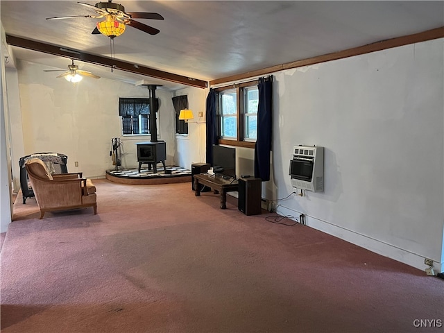 living room with vaulted ceiling with beams, a wood stove, heating unit, carpet flooring, and ceiling fan