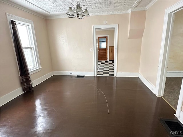 empty room with ornamental molding, dark hardwood / wood-style flooring, and a notable chandelier