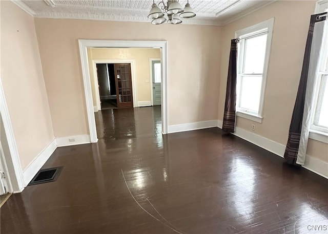 unfurnished room with dark wood-type flooring, ornamental molding, and a notable chandelier