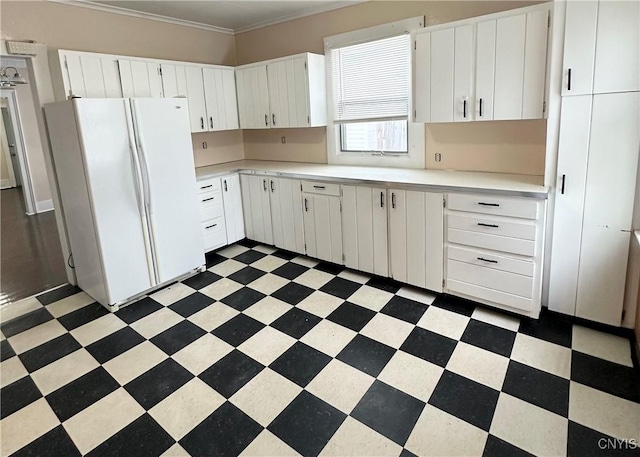 kitchen with crown molding, white cabinets, and white refrigerator