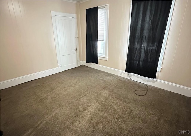 spare room featuring dark carpet