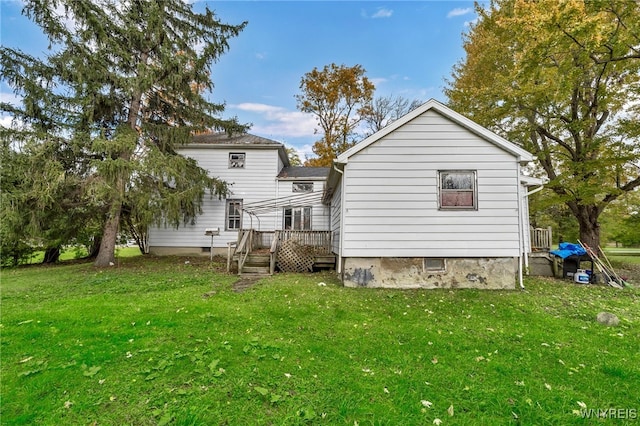 back of property with a yard and a deck