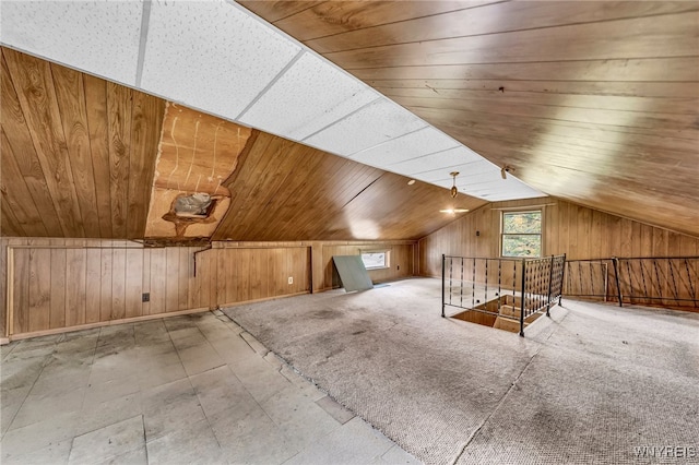 bonus room featuring lofted ceiling, wood ceiling, and wood walls