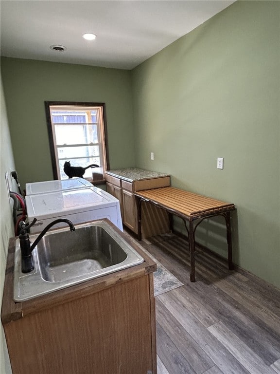 kitchen with washing machine and clothes dryer, sink, and light hardwood / wood-style flooring