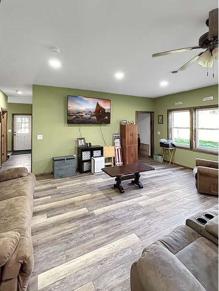 living room with ceiling fan and light hardwood / wood-style flooring