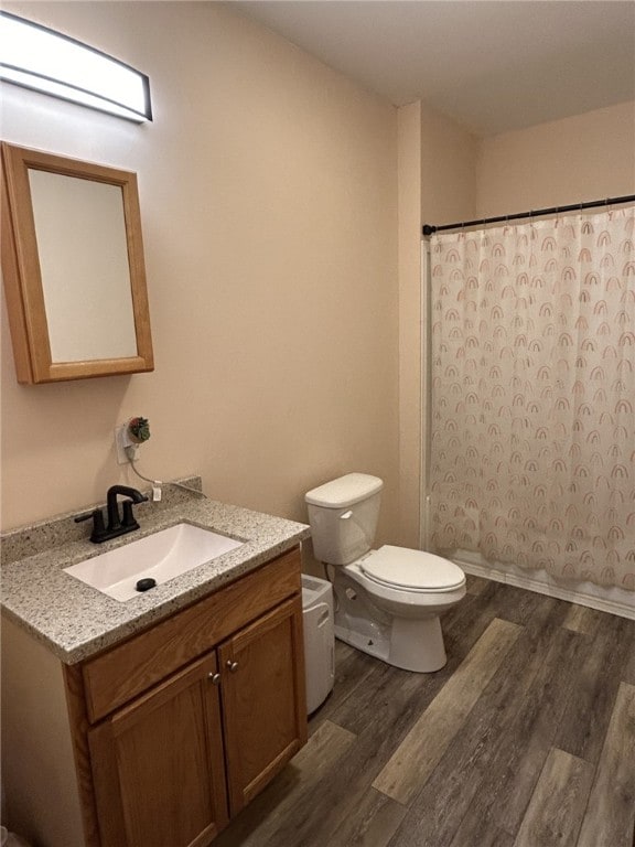 bathroom featuring vanity, a shower with shower curtain, toilet, and wood-type flooring