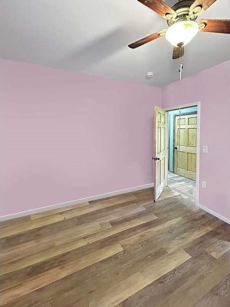 empty room featuring hardwood / wood-style floors and ceiling fan