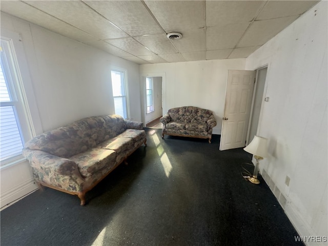 carpeted living room with a paneled ceiling