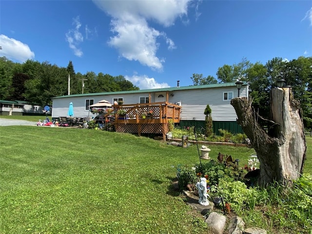 back of property with a yard and a wooden deck