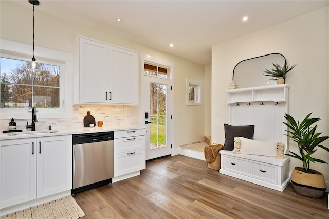 kitchen with white cabinets, dishwasher, sink, and hanging light fixtures