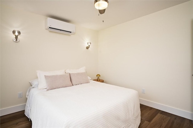 bedroom with ceiling fan, an AC wall unit, and dark wood-type flooring