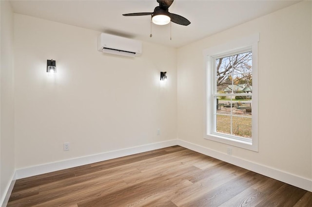 unfurnished room with a wall unit AC, ceiling fan, and hardwood / wood-style floors