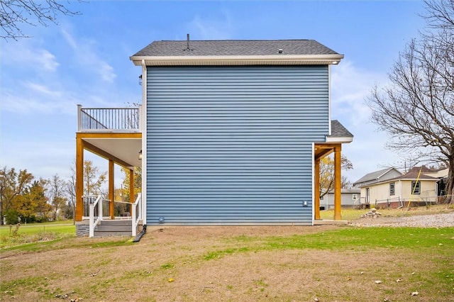 view of home's exterior featuring a balcony and a yard