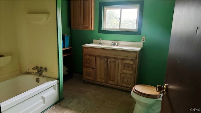 bathroom featuring tile patterned floors, vanity, a tub to relax in, and toilet