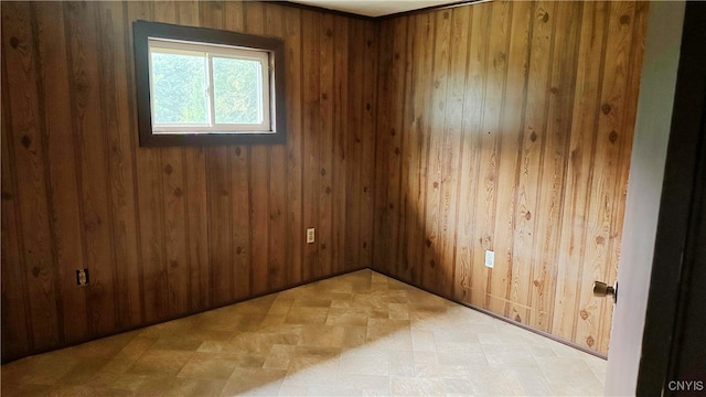 unfurnished room featuring wood walls