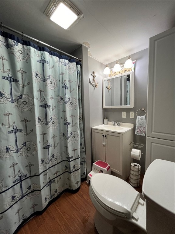 bathroom with hardwood / wood-style floors, curtained shower, vanity, and toilet