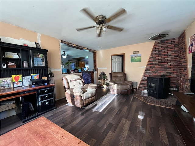 living room with dark wood-type flooring, ceiling fan, and a wood stove