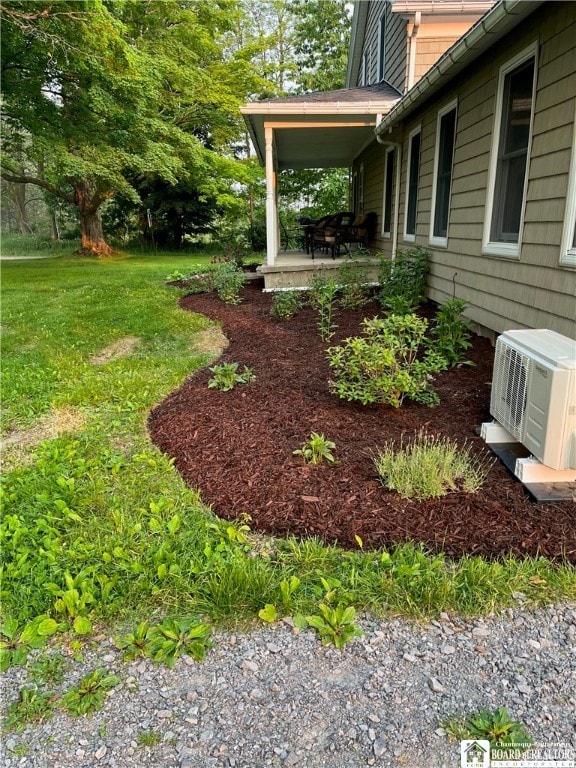 view of yard with ac unit and a porch