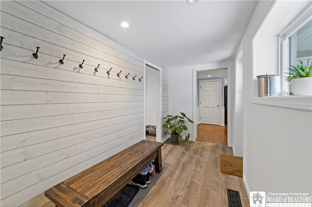 mudroom featuring wood walls and light wood-type flooring