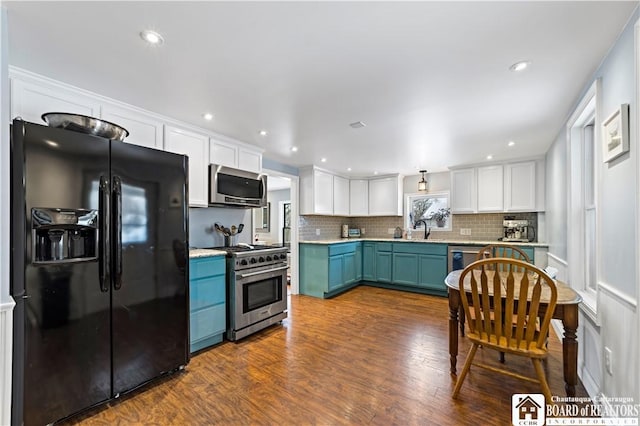 kitchen with backsplash, stainless steel appliances, blue cabinetry, dark hardwood / wood-style floors, and white cabinetry