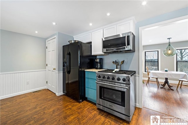 kitchen with light stone counters, white cabinets, dark hardwood / wood-style floors, and appliances with stainless steel finishes