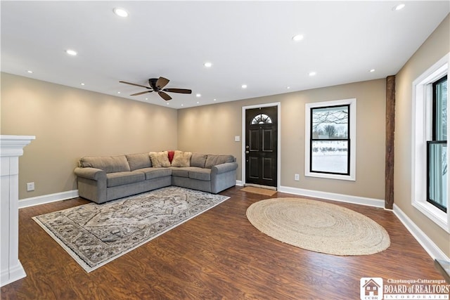 living room with ceiling fan and dark wood-type flooring