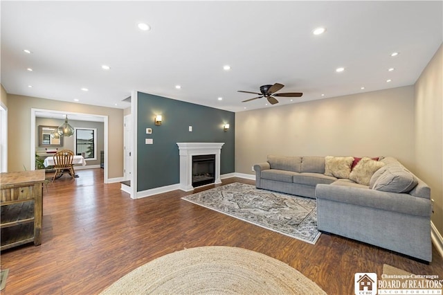 living room with ceiling fan and dark hardwood / wood-style flooring