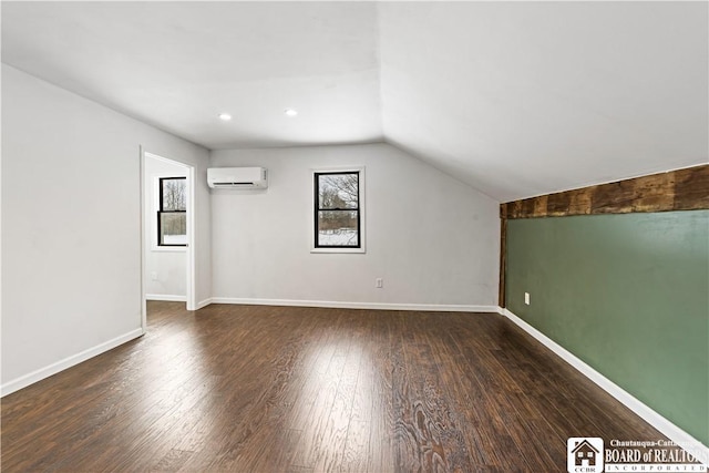 additional living space featuring an AC wall unit, vaulted ceiling, and dark hardwood / wood-style floors