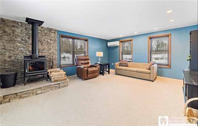 carpeted living room with an AC wall unit and a wood stove