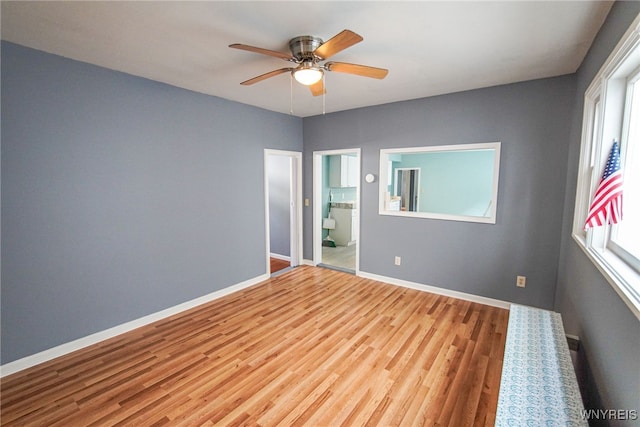 empty room with light hardwood / wood-style flooring, a healthy amount of sunlight, and ceiling fan