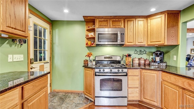 kitchen featuring stainless steel appliances and dark stone counters