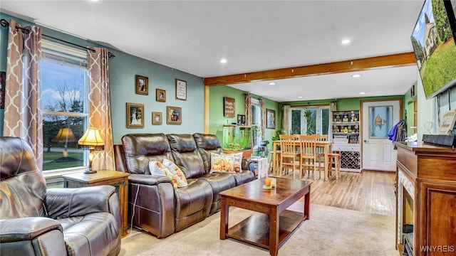 living room with beamed ceiling and light hardwood / wood-style flooring