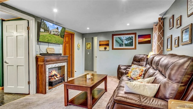 carpeted living room featuring a stone fireplace