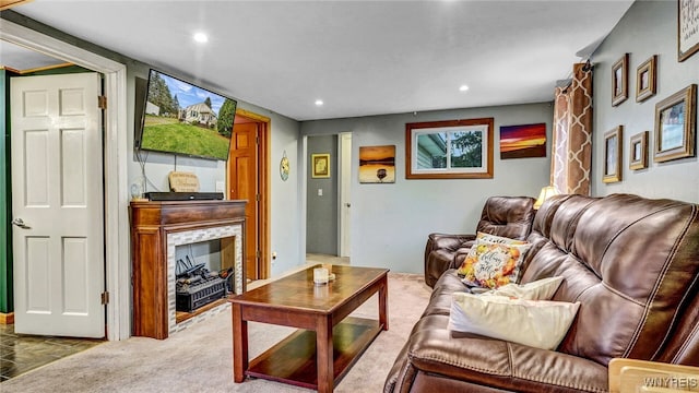 carpeted living room with a stone fireplace