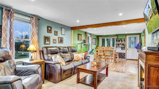 living room featuring light wood-type flooring and beamed ceiling