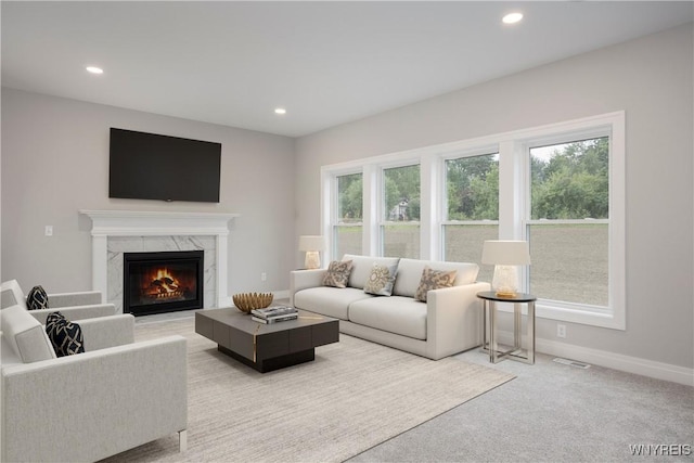 living room featuring a fireplace and light colored carpet