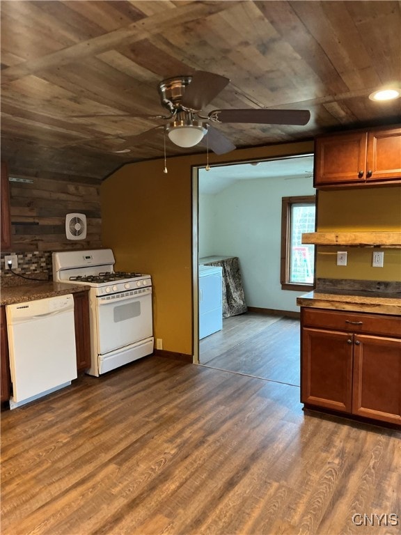 kitchen with dark hardwood / wood-style floors, washer / clothes dryer, vaulted ceiling, white appliances, and ceiling fan